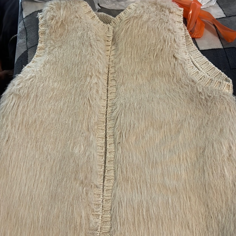 Cream colored. Short sleeve cardigan.